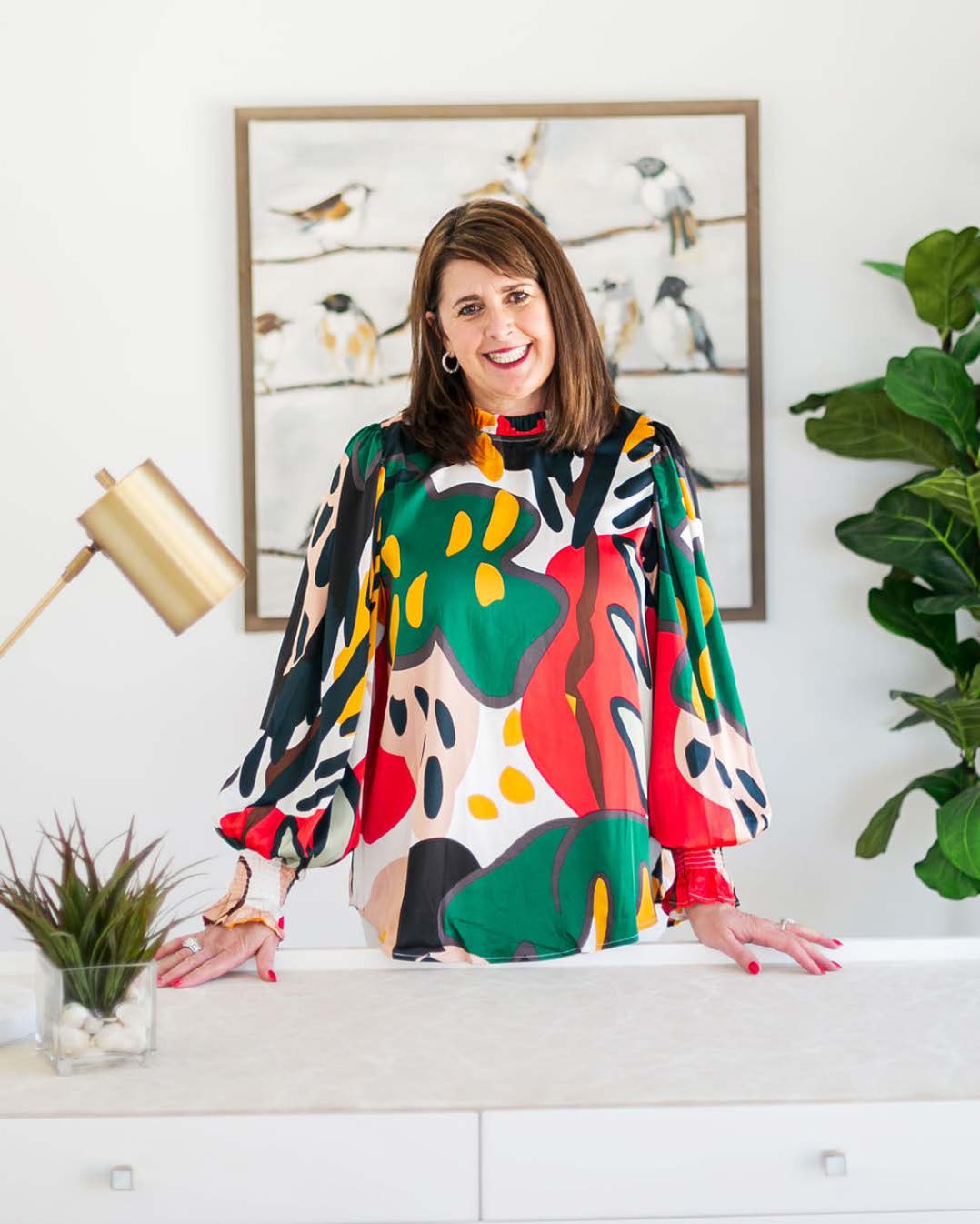 Dana McQueen- McQueen_s Interiors A person wearing a colorful shirt standing behind a desk