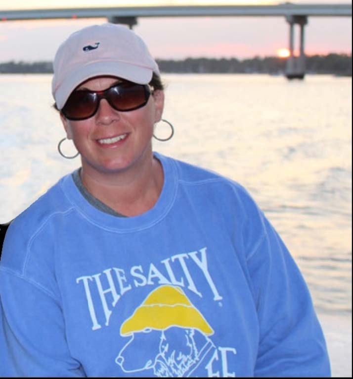 Krista Purves- Crystal Coast Boat Charters & Rentals a person on the water with the sun setting in the background