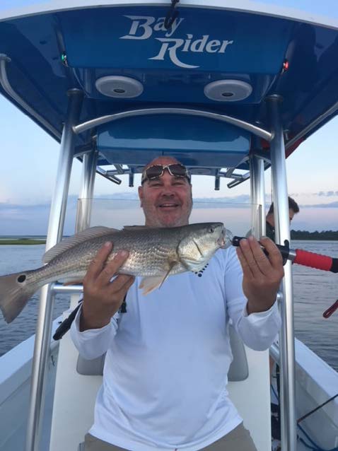 Tim Johnson- Pirates Life 4 Us Fishing Charters a person on a boat holding a fish with water in the background